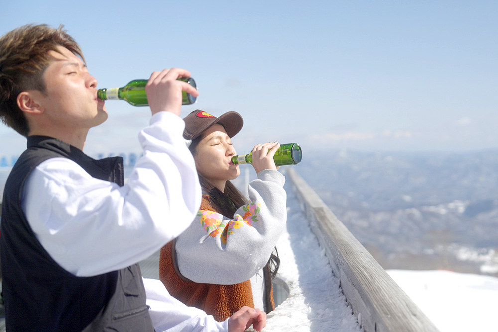 山頂でビールを飲む写真
